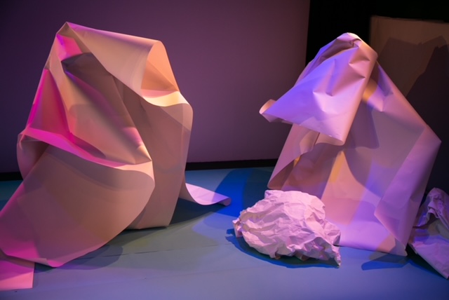 Two crumpled paper sculptures are beside each other. They look like icebergs.